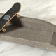 A miniature Tech Deck skateboard on top of a D.I.Y. Concrete creation.